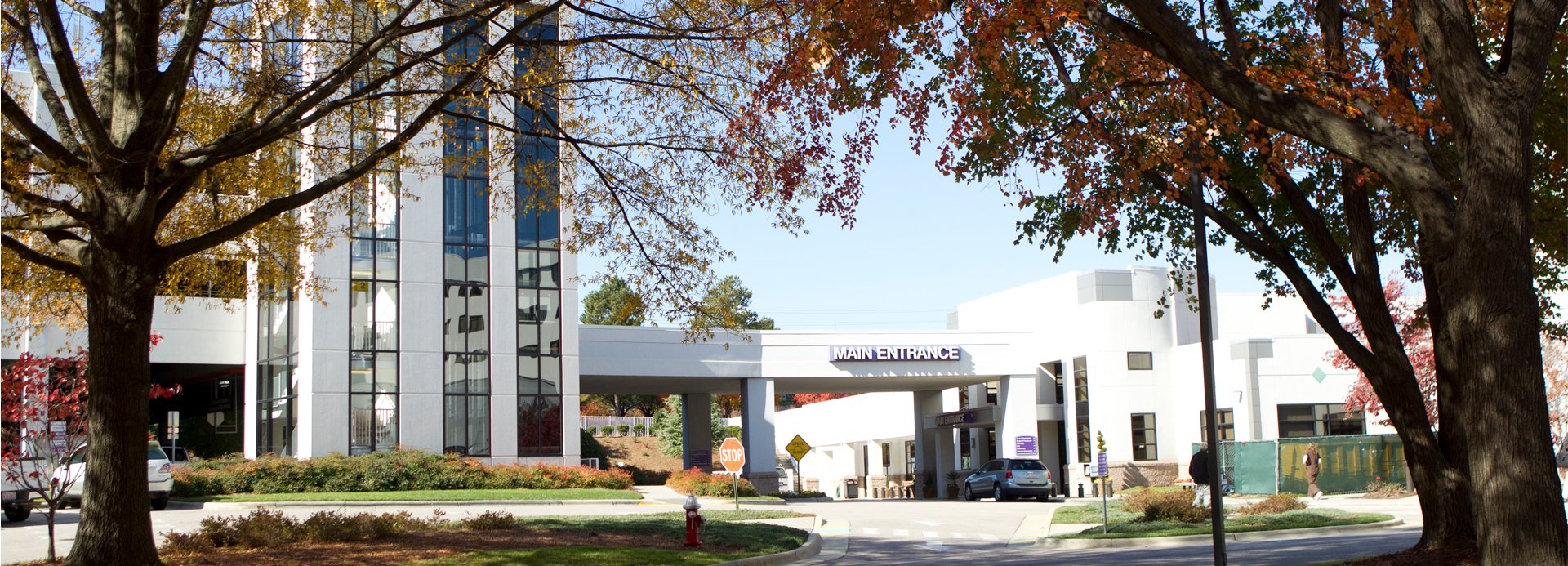 Main entrance of REX Hospital with beautiful fall foliage on the trees in the foreground